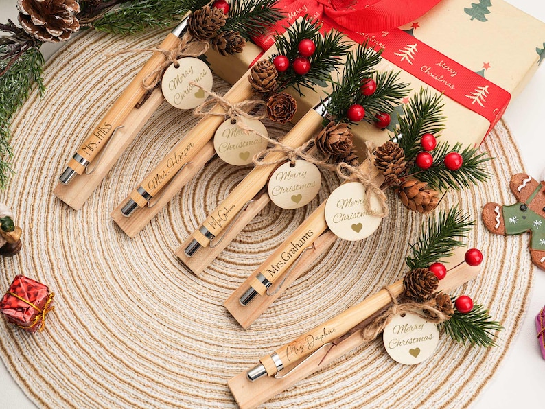 Personalized wooden pens with wooden charm ornaments make thoughtful teacher appreciation gifts, engraved with "Merry Christmas" and custom names for holiday giving. Etsy
