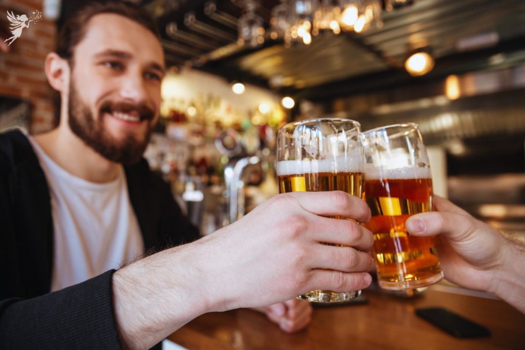 a happy father in beard cheers beer glasses in a brewery for fathers day