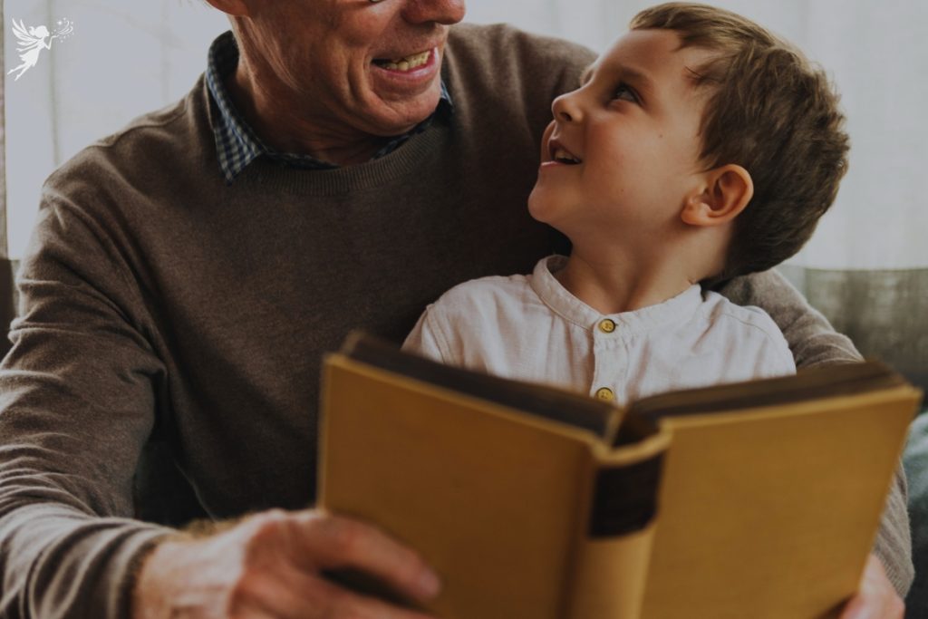 grandfather and young child reading a book togetehr