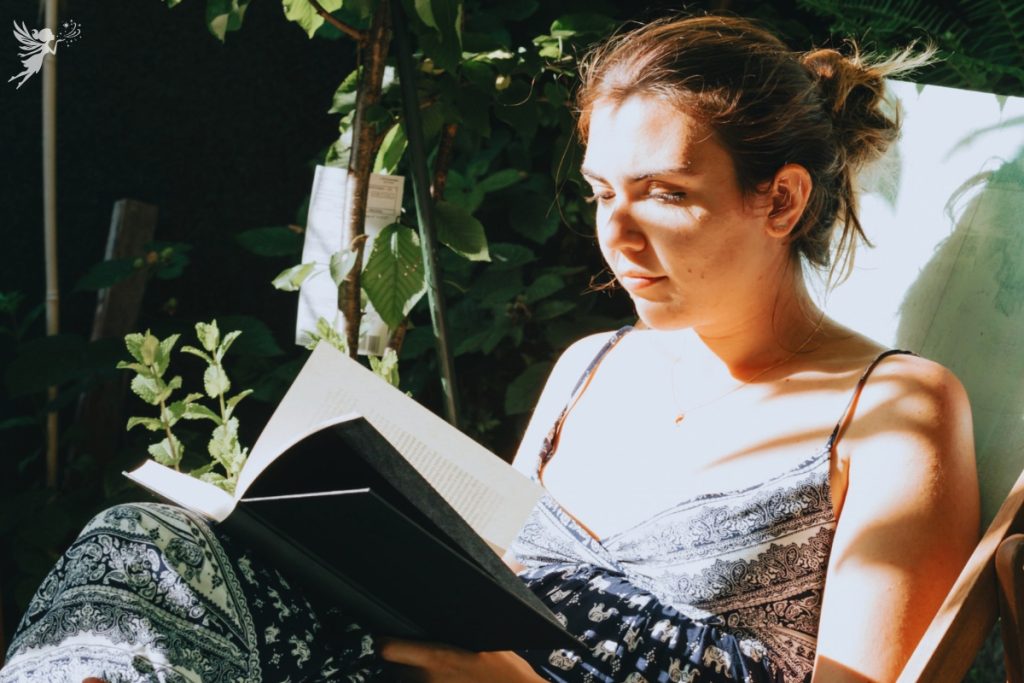 mother relaxing quietly in a sun dappeled garden enjoying a book alone quiet experience gift idea mothers day