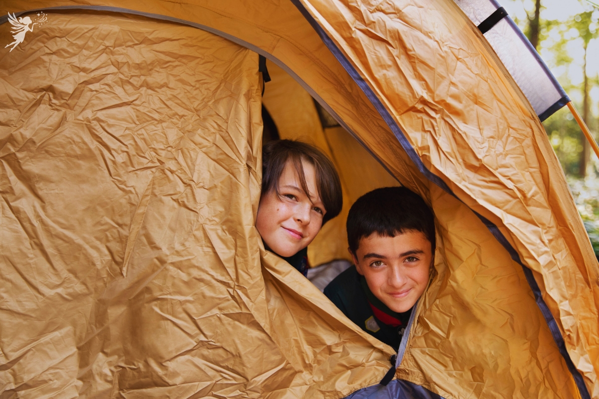 boys sticking their heads out of a beige brown tent