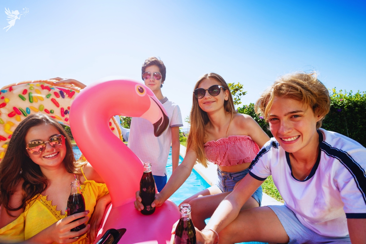 a group of teenagers in swimwear with a flamingo float in the bright sunshine