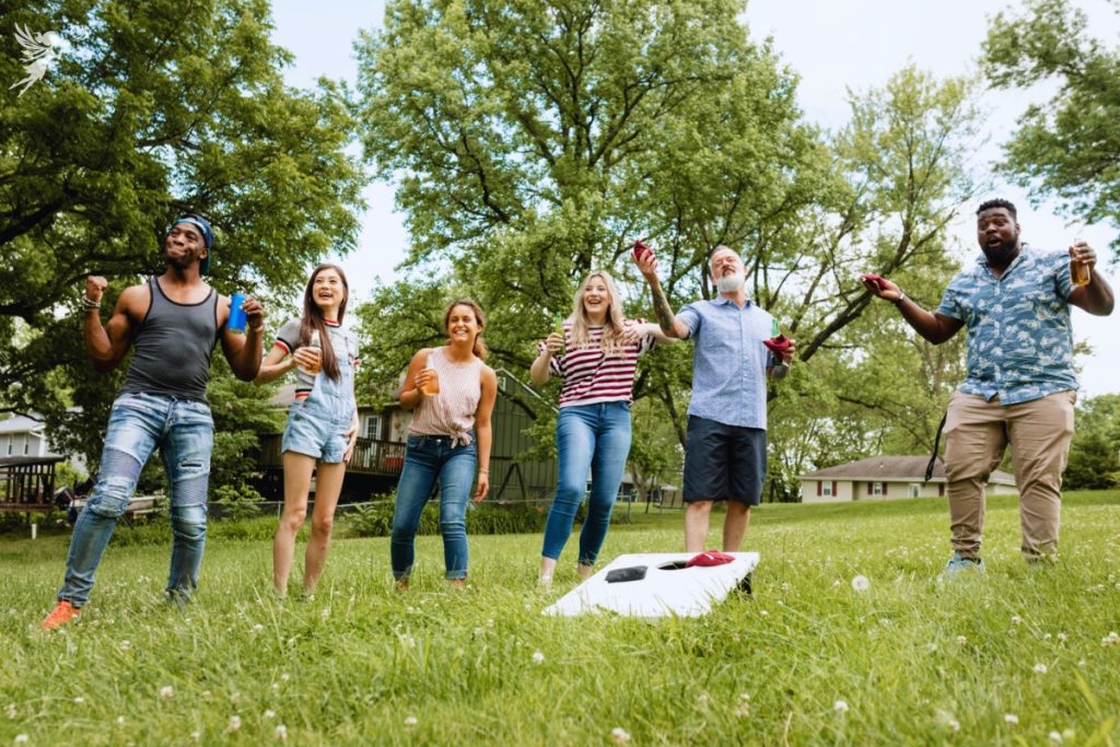 group of adults playing garden cornhole