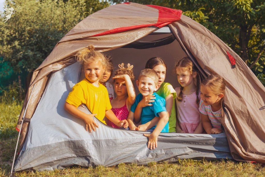group of kids sticking their heads out of a tent 