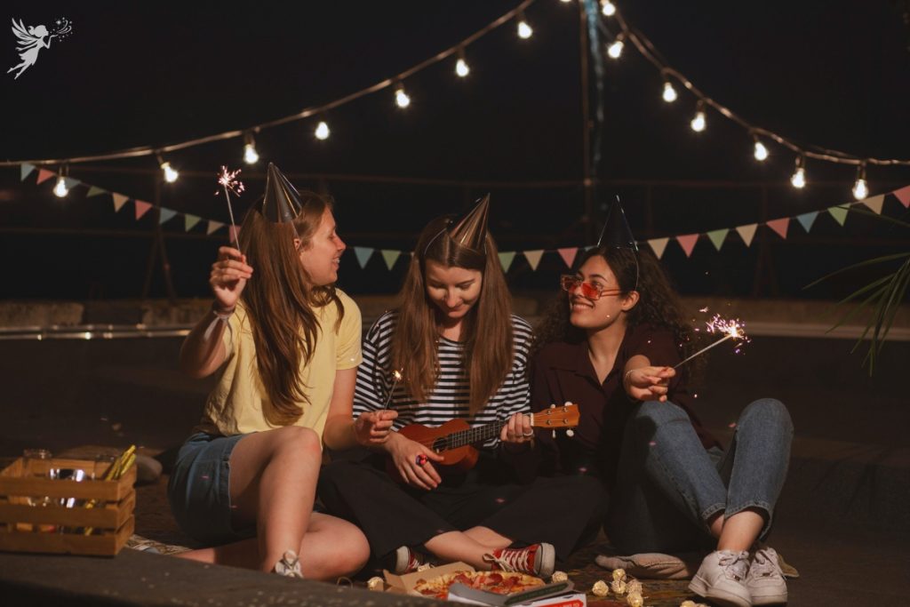 teen girls havin an outdoor party under fairy lights