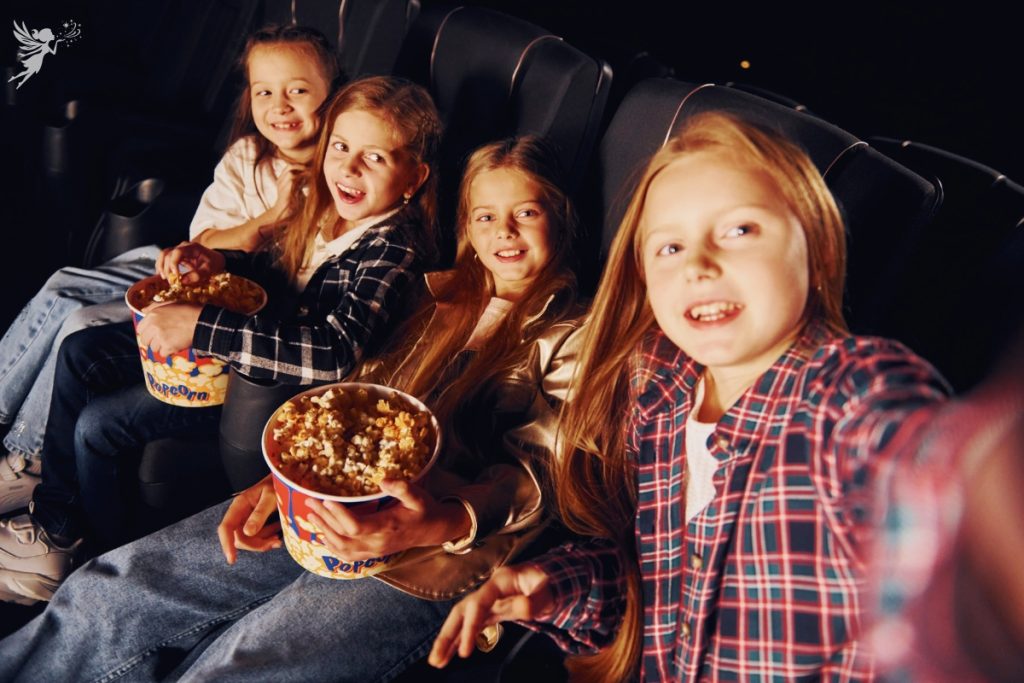 tween girls in a cinema with bucket of popcorn