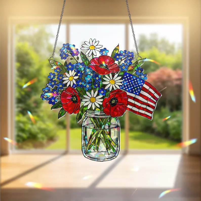 A stained glass-style patriotic flower suncatcher with red poppies, daisies, blue wildflowers, and an American flag in a mason jar — elegant 4th of July hostess gifts. Etsy