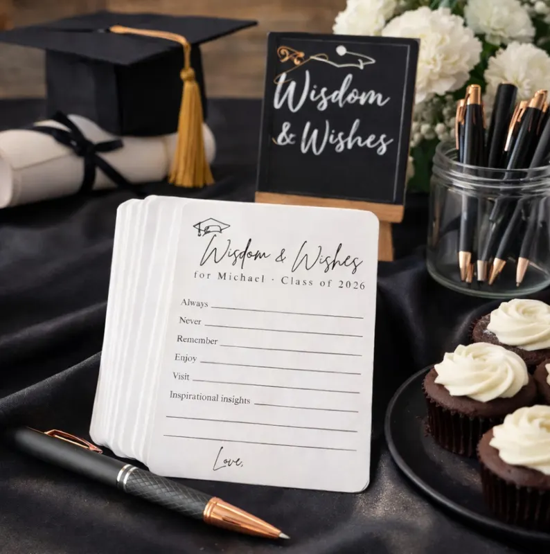 Stack of printed "Wisdom and Wishes" advice cards personalized for Michael Class of 2026, displayed beside cupcakes and pens, among the most interactive graduation gifts. Etsy
