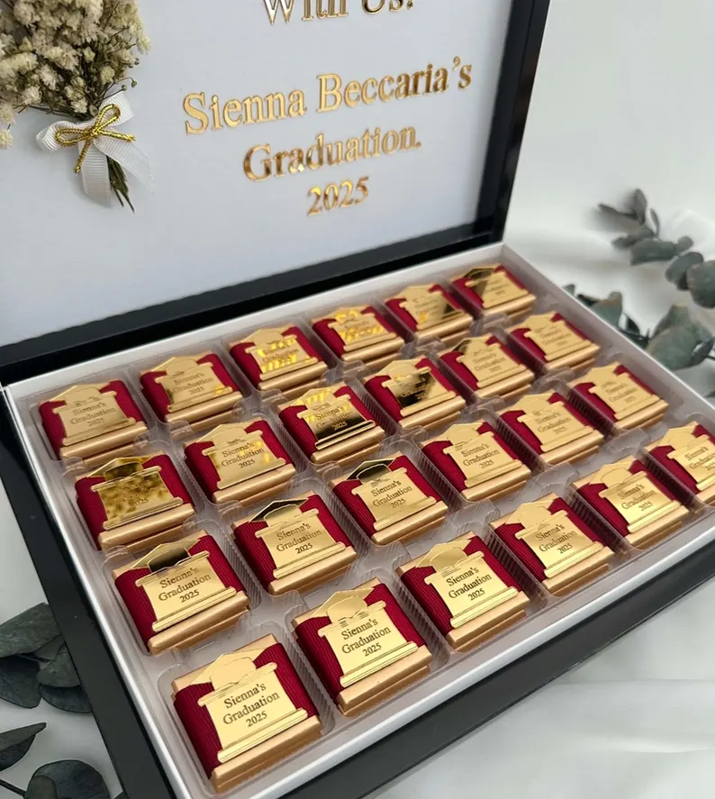 Elegant black box filled with individually wrapped chocolates topped with gold graduation cap charms personalized for Sienna's graduation, perfect as graduation gifts. Etsy