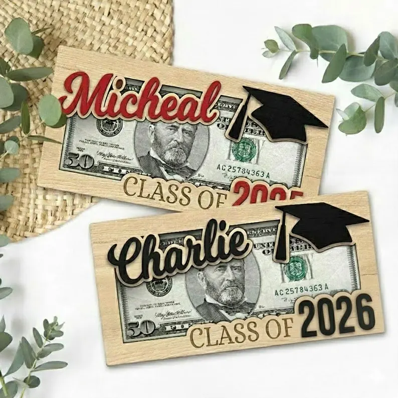 Two personalized wooden money holder frames with graduation caps and names Micheal and Charlie engraved, showcasing a fun way to present graduation gifts. Etsy