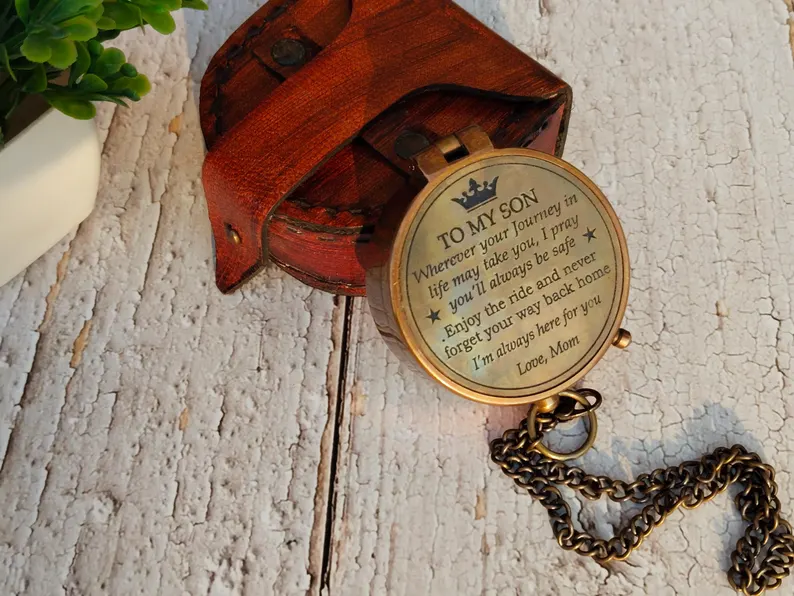 Antique brass compass engraved with a heartfelt message to a son, paired with a rustic leather pouch, among the most sentimental graduation gifts. Etsy