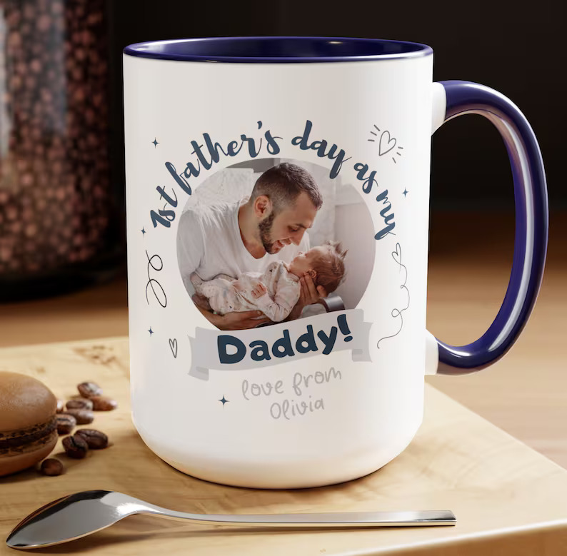 A navy accented white ceramic mug printed with a dad and newborn photo reading "1st Father's Day as My Daddy," a personalized and touching first Father's Day gift idea. Etsy