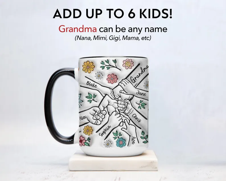 White ceramic mug featuring holding hands design with customizable grandchildren names and colorful flowers, personalized grandma gifts from grandkids keepsake.