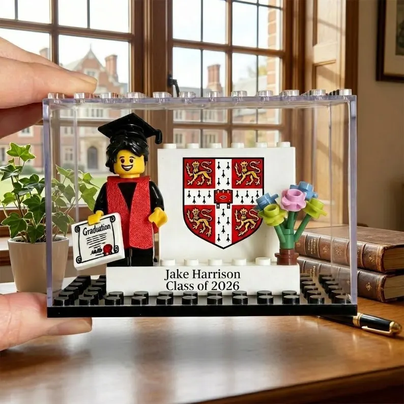 Custom LEGO minifigure dressed in graduation cap and gown displayed inside a clear case with a personalized nameplate, one of the most unique graduation gifts. Etsy