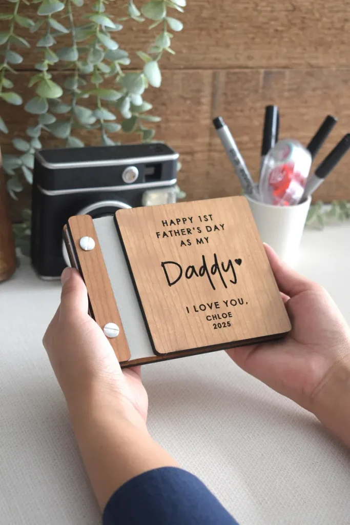 Hands holding a small wooden mini photo book engraved with "Happy 1st Father's Day as My Daddy," a sweet and memorable first Father's Day gift idea. Etsy