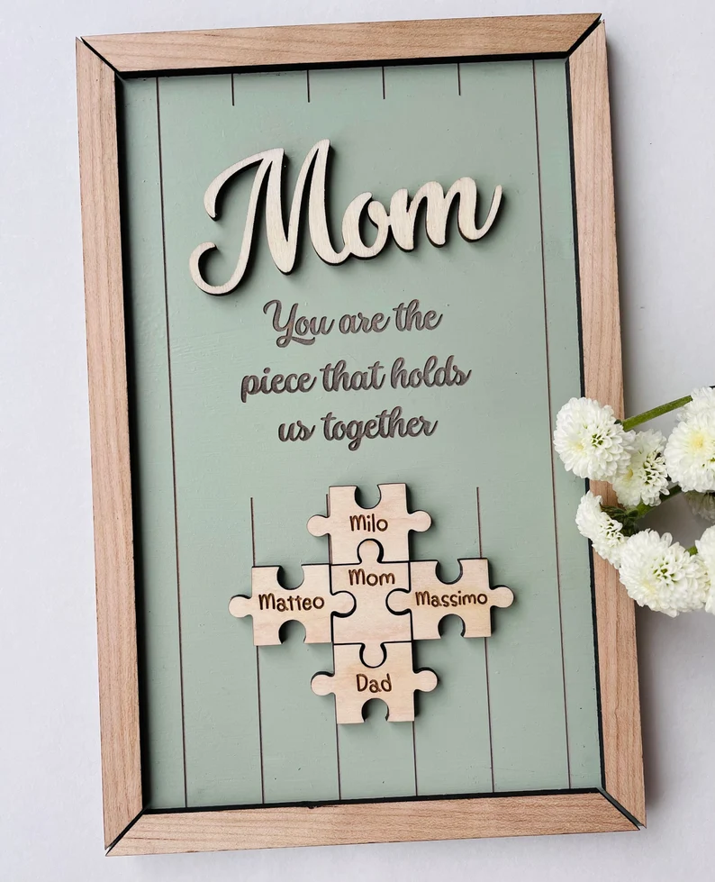Wooden puzzle piece shadow box with family names saying piece that holds us together, meaningful mom sentimental gifts display. Etsy