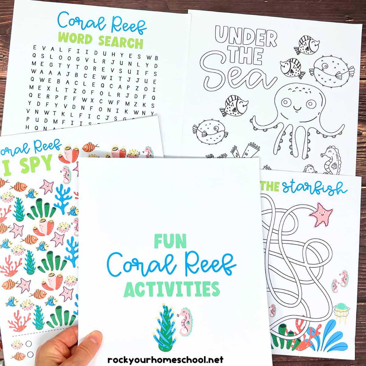 A set of printable coral reef activity sheets including a word search, coloring page, and starfish maze spread on a wooden surface
