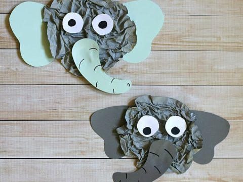 Two crumpled newspaper elephant face crafts with paper ears and googly eyes for safari party crafts and activities