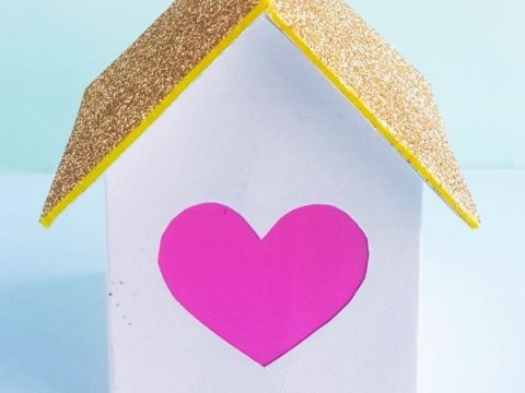 A cute white and gold glitter fairy house with a heart cutout, a printable fairy party crafts and activities project that lights up.