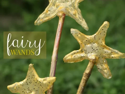 Three golden glittery star-topped fairy wands made from sticks, a simple and magical fairy party crafts and activities kids will treasure.