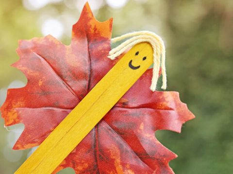 A handmade fall fairy puppet using a craft stick and a colorful leaf, a creative fairy party crafts and activities idea for kids.
