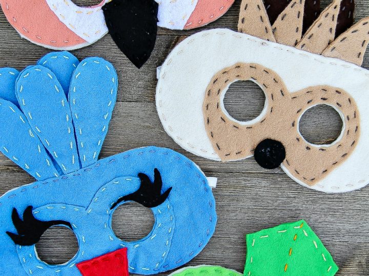 Colorful handmade felt jungle face masks in pink, blue, and green for safari party crafts and activities