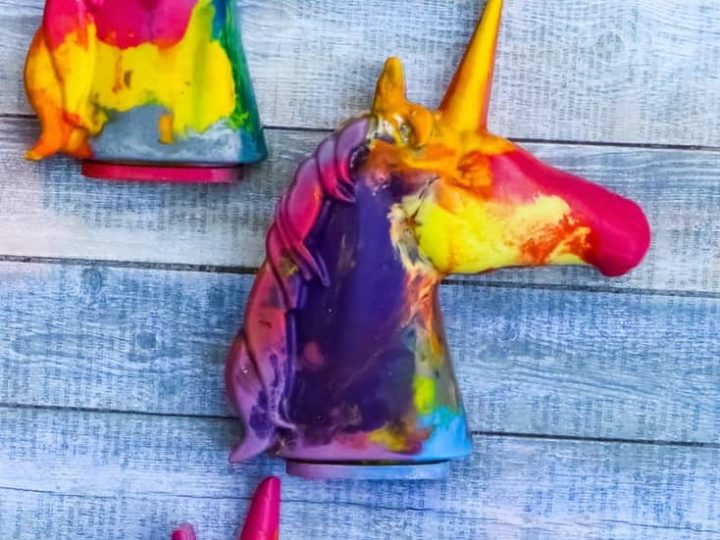 Colorful melted crayon unicorn head shapes in swirled rainbow colors are unique and creative unicorn party crafts and activities