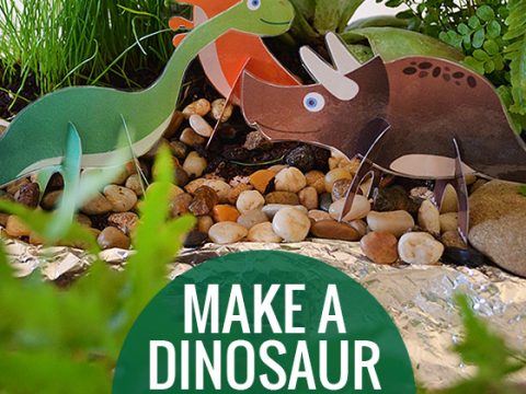Miniature dinosaur garden centerpiece with printable paper dinosaurs, pebbles, and green plants for a party table display