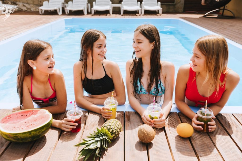 teen girs side of pool with fruit and shakes