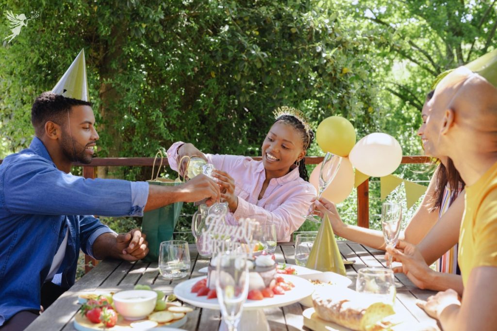 adult friends at outdoor table enjoying snacks and wine