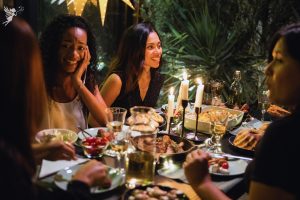 adults at sophisticated outdoor evening party by candlelight outdoors