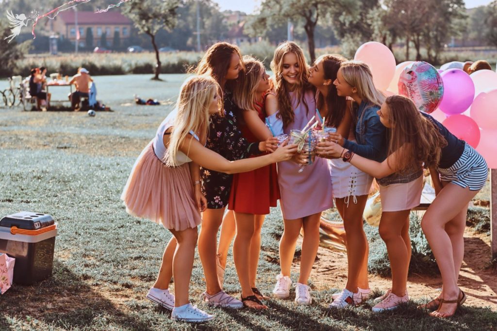 group of teen frineds in park celebrting a birthday