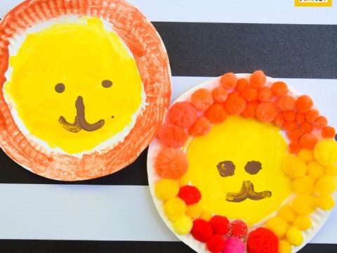 Paper plate lion crafts with painted faces and colorful pom pom manes for safari party crafts and activities