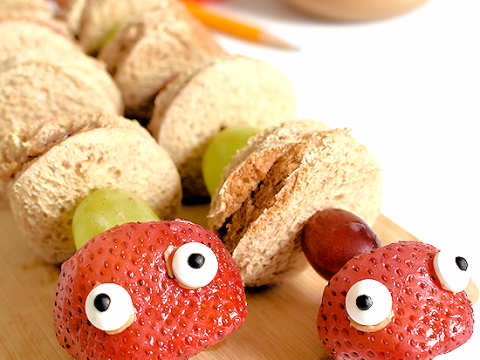 PB&J mini sandwich and grape snake skewers with strawberry heads and candy eyes, creative safari animal party food ideas