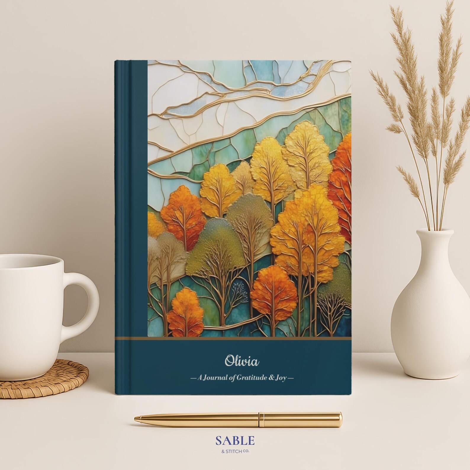 Personalized autumn gratitude journal with stained glass fall forest cover — a meaningful and elegant Thanksgiving hostess gift idea she'll treasure.