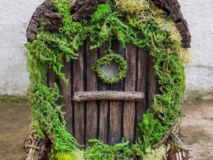 A charming miniature gypsy wagon made from a tin can with moss and twigs, perfect for fairy party crafts and activities.