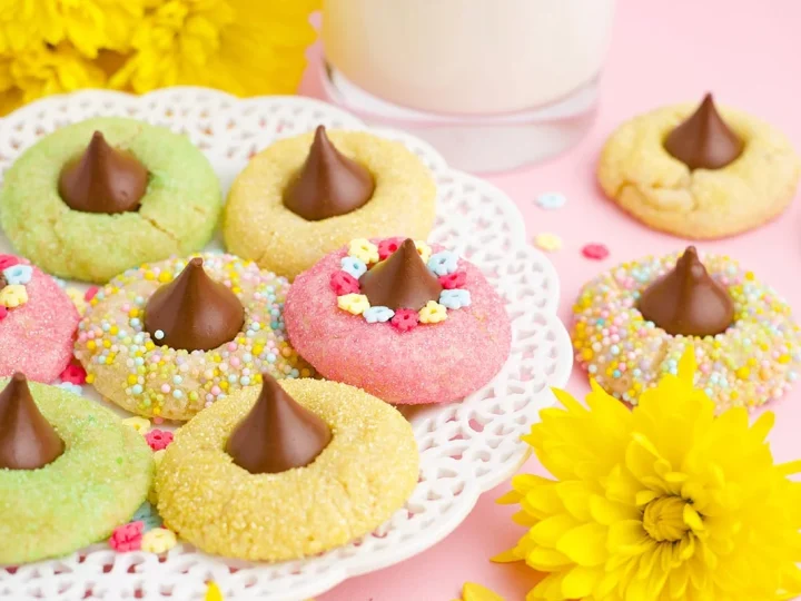 Colorful pastel spring blossom thumbprint cookies with chocolate kiss centers and flower sprinkles — a pretty and festive fairy party food treat for garden parties.