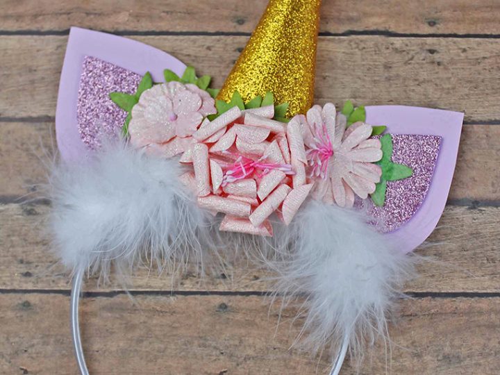 A handmade unicorn headband with a glitter gold horn ribbon flowers and fluffy white feathers is a showstopping unicorn party craft and activity