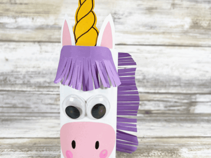 A toilet paper roll unicorn with purple fringe mane and gold glitter horn makes a fun unicorn party craft and activity for kids
