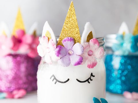 Decorated mason jars with glitter horns felt ears and paper flowers make magical unicorn party crafts and activities for kids