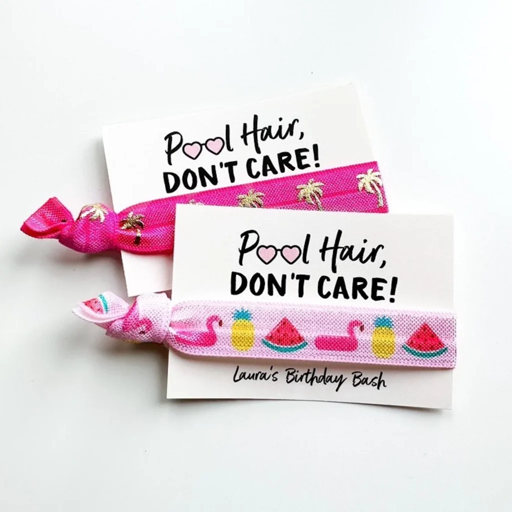Two pink hair ties with tropical and summer prints on Pool Hair Don't Care cards, cute personalized pool party favors.