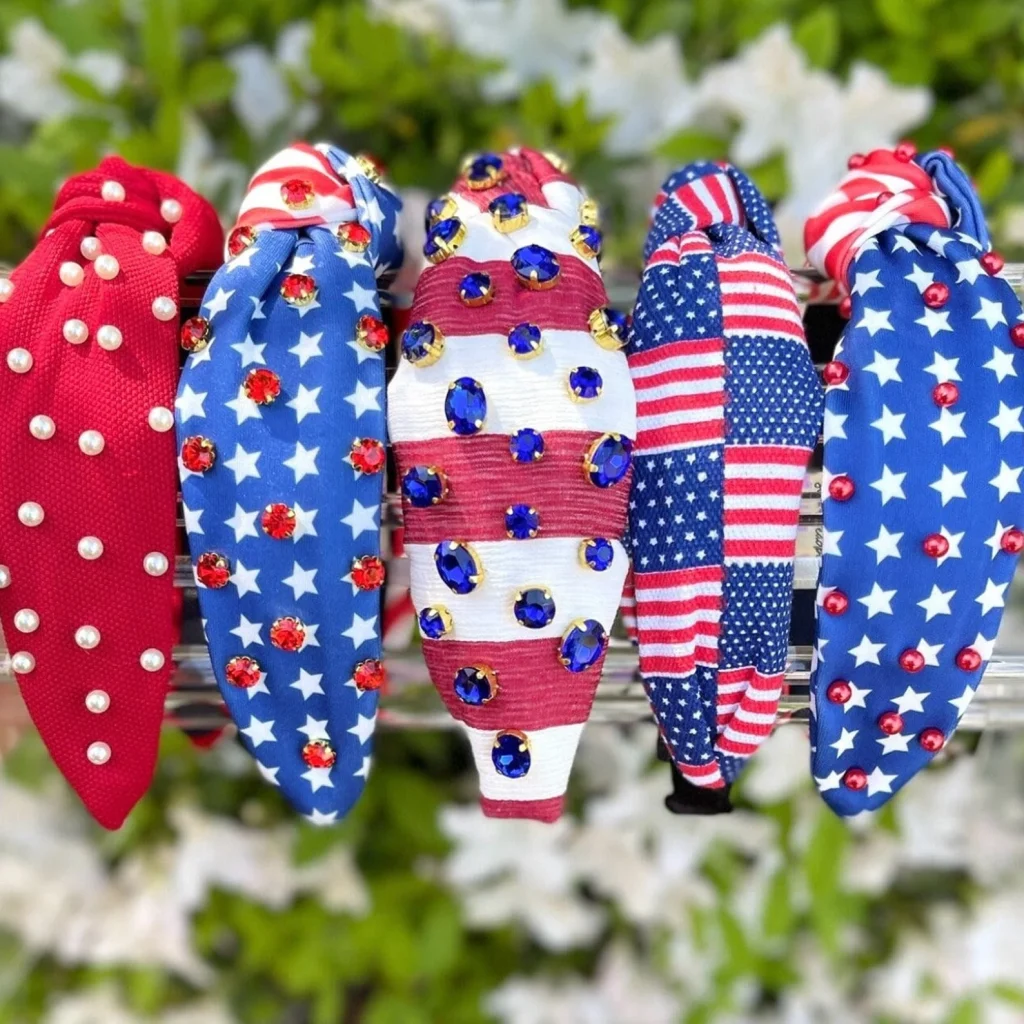 Five embellished patriotic knotted headbands featuring stars and stripes patterns with pearl and rhinestone details, stylish 4th of July party favors.
