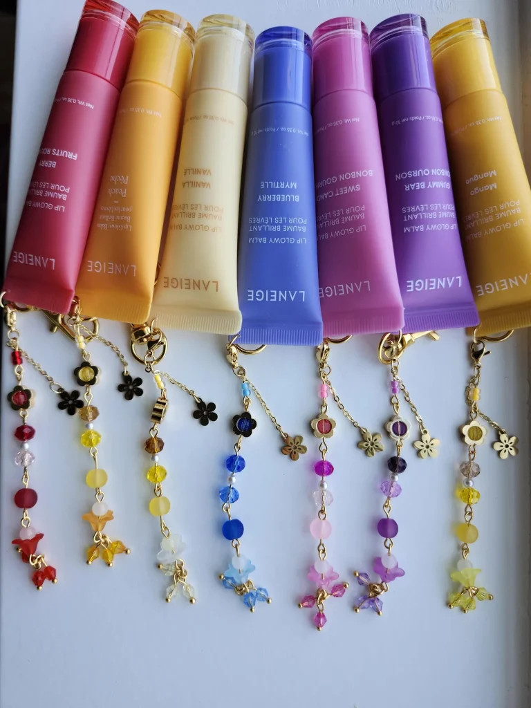 Seven colorful Laneige lip gloss balms with decorative beaded flower keychains in matching hues, adorable and practical pool party favors.
