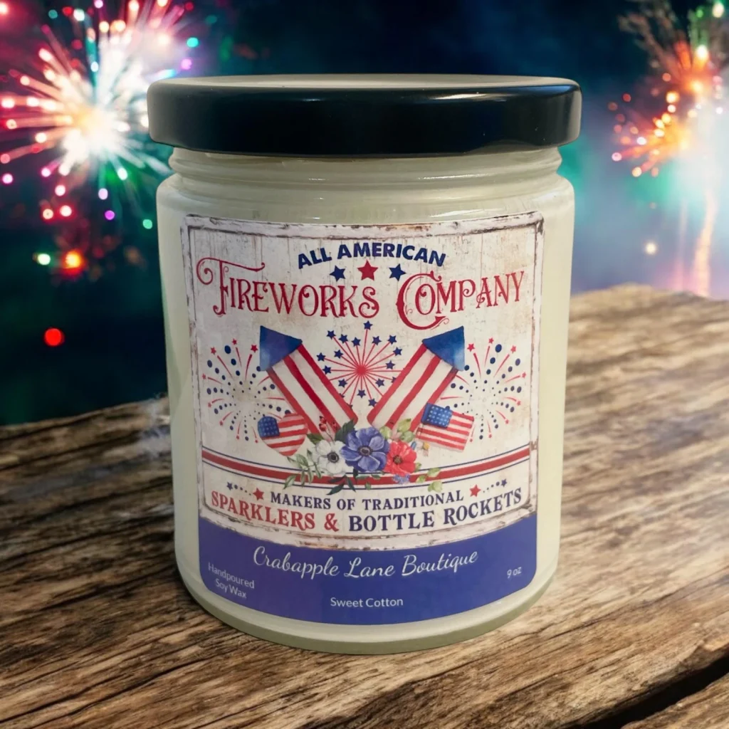 Vintage-style All American Fireworks Company soy wax candle with patriotic label displayed against a fireworks backdrop, charming 4th of July party favors.