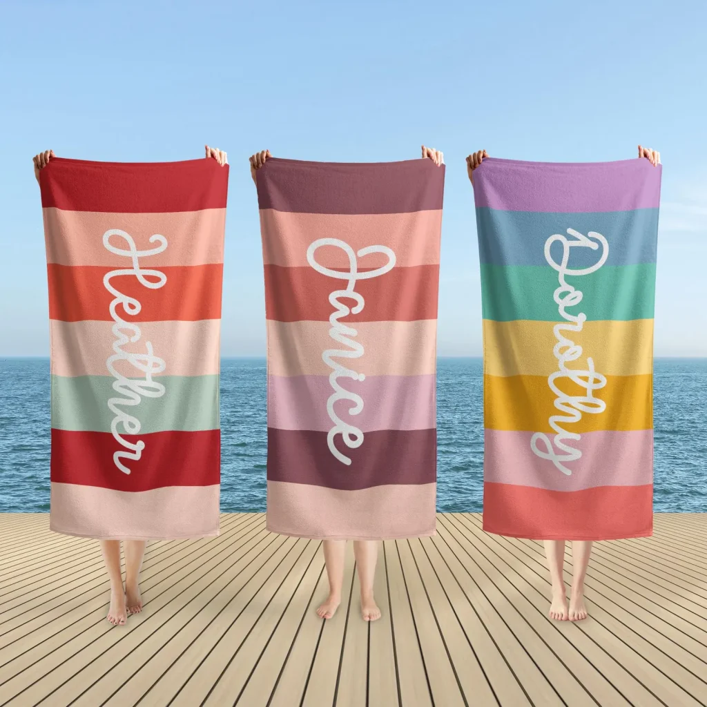 Three people holding custom name rainbow striped beach towels in vibrant colors, fun and memorable pool party favors for everyone.
