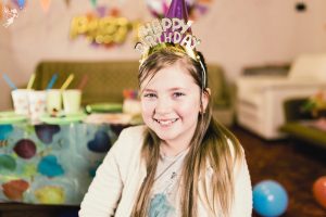 smiling 11 year old girl with a happy birthday crown