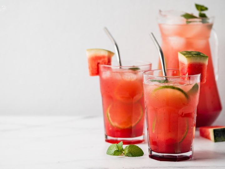waterlemon mint drink in glasses with a carafe behind filled with icy watermelon drink