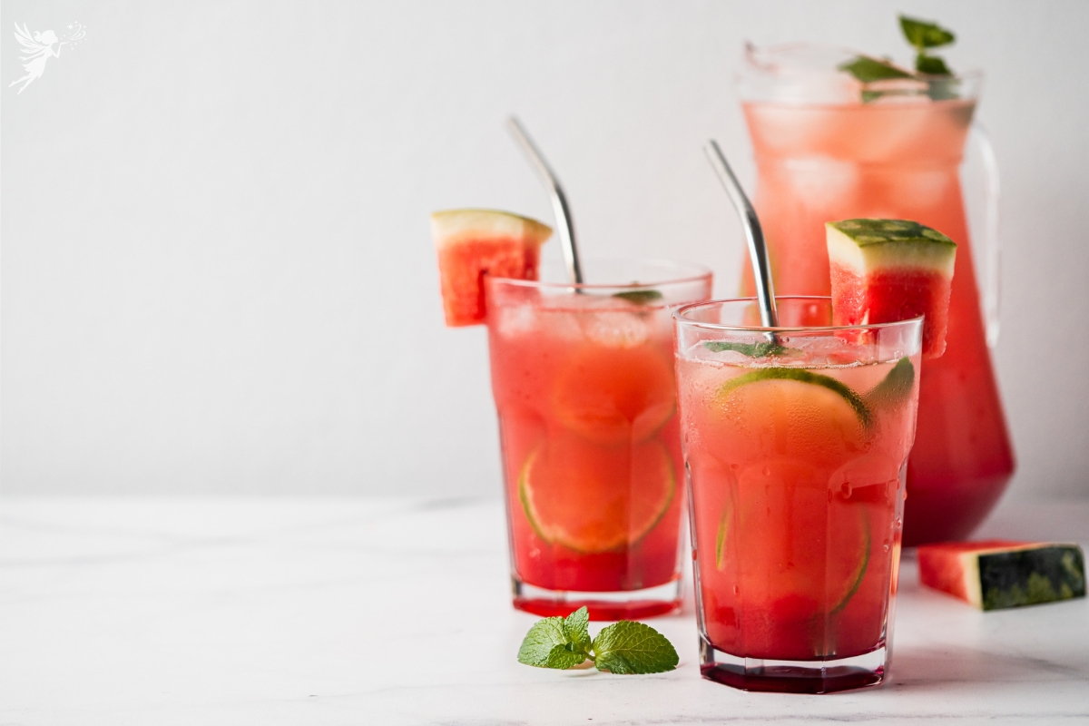 waterlemon mint drink in glasses with a carafe behind filled with icy watermelon drink