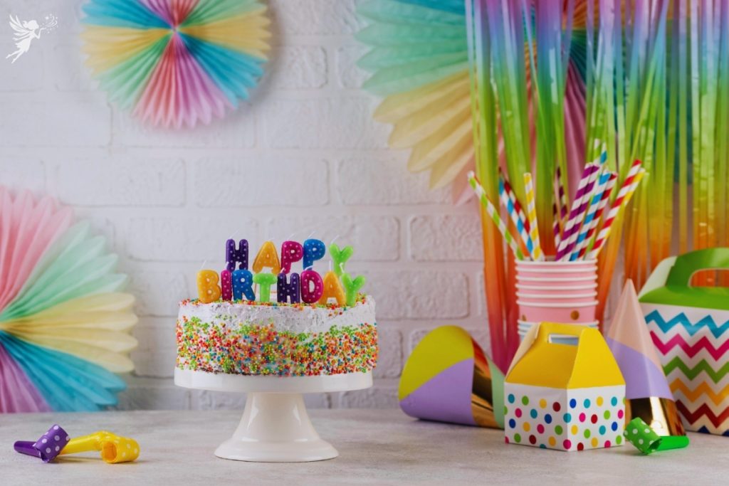 colorful rainbo themed cake and birthday party set up