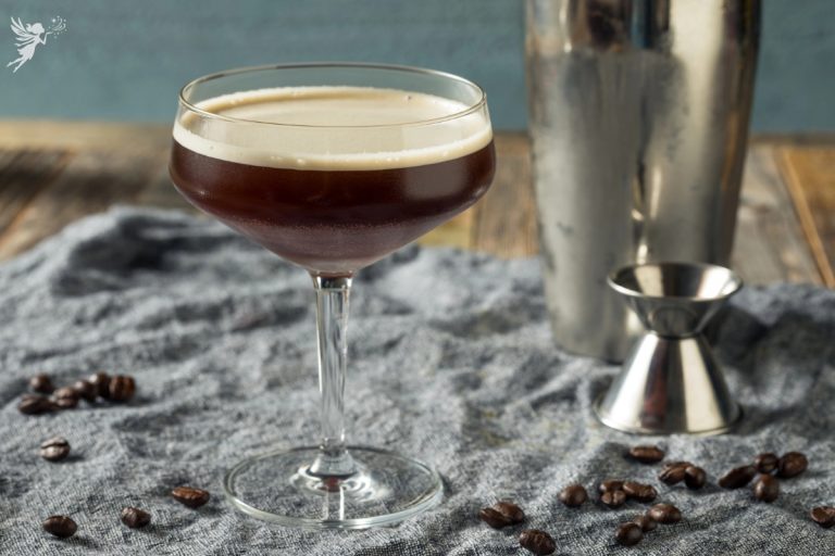 close up of a glass of espresso martini mocktail being prepared with a cocktail shaker and jigger